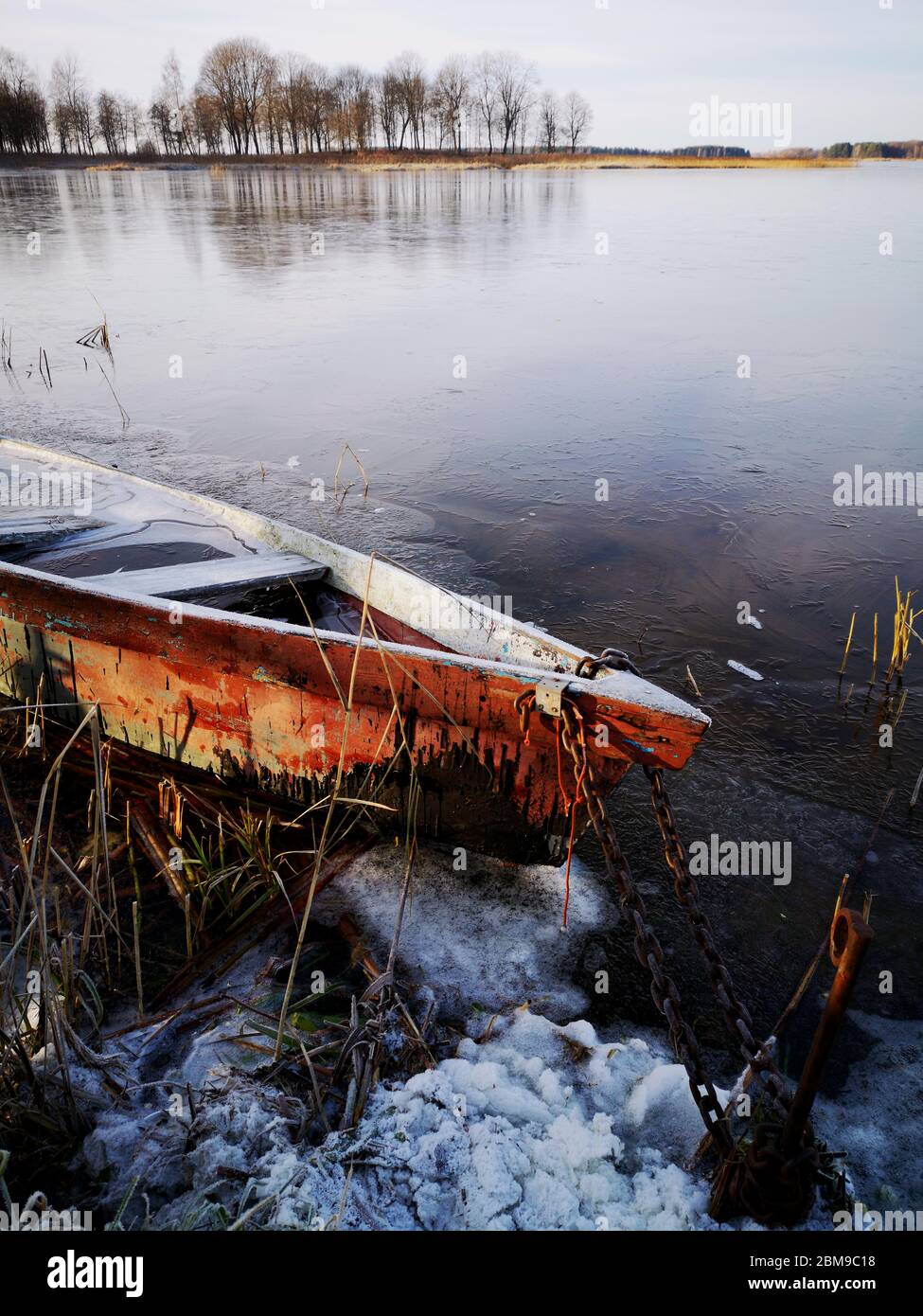 Boat on lake ice. Winter time landscape composition. Stock Photo