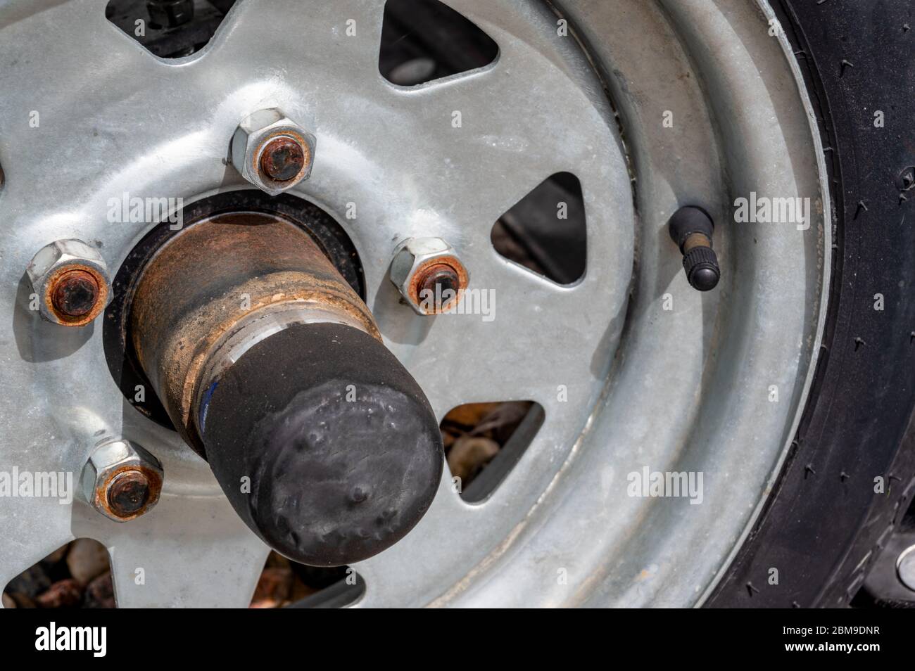 trailer grease cap on rusted tire frame Stock Photo Alamy