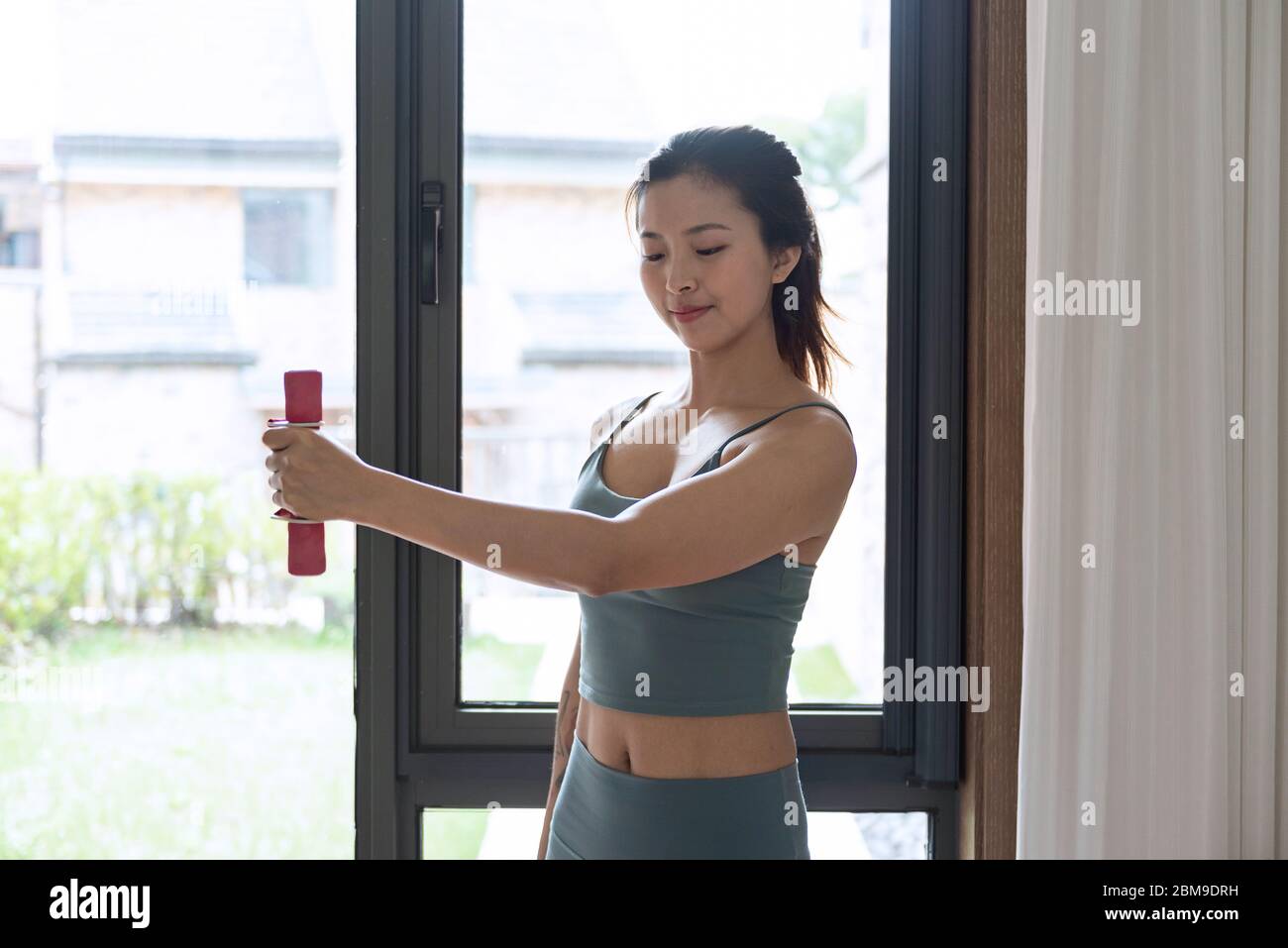 A young Asian woman doing yoga at home Stock Photo