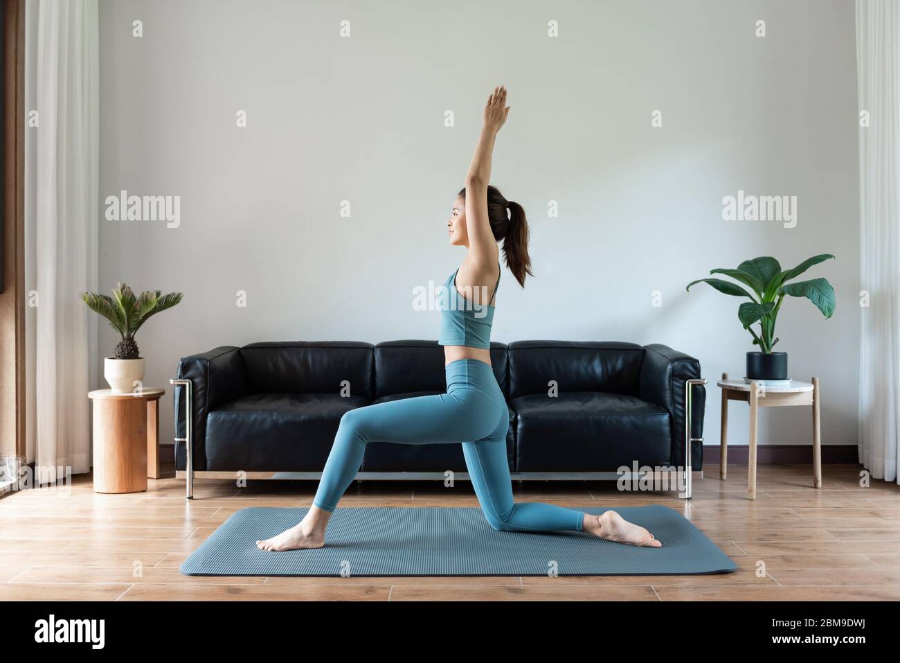 A young Asian woman doing yoga at home Stock Photo - Alamy