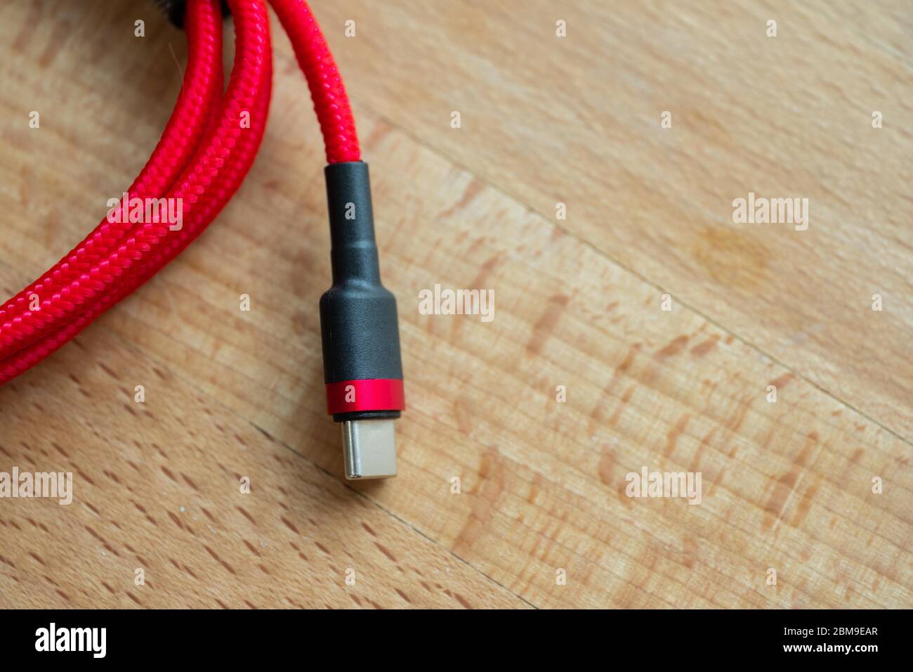 The USB type c is a hi speed data transfer and quick or fast charge battery.It a new connector port of a computer , laptop, or cell phone.A red cable Stock Photo