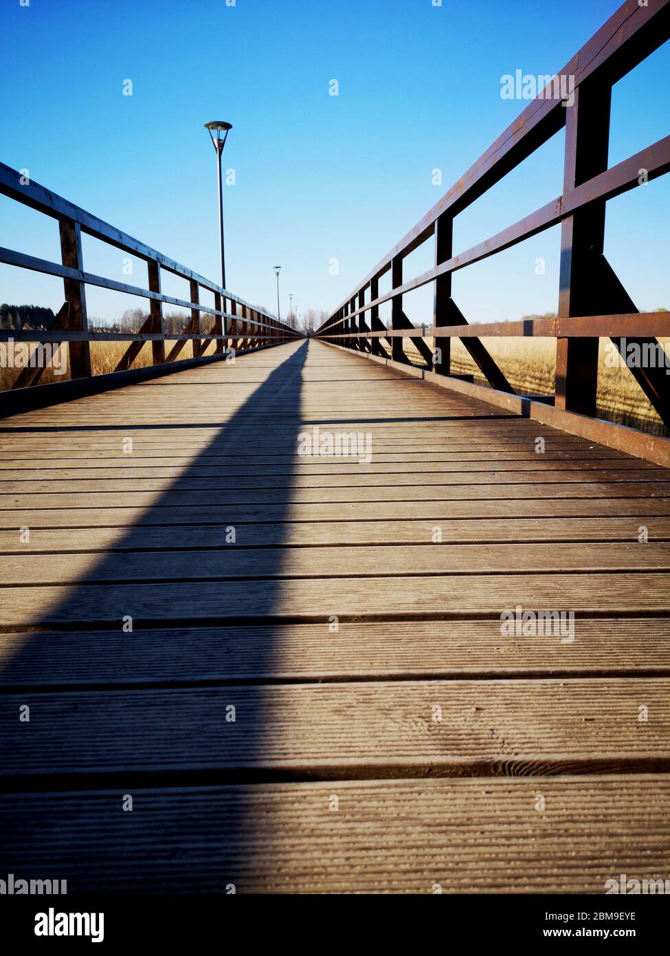 Empty new wooden bridge with lamps and fence shadow Stock Photo