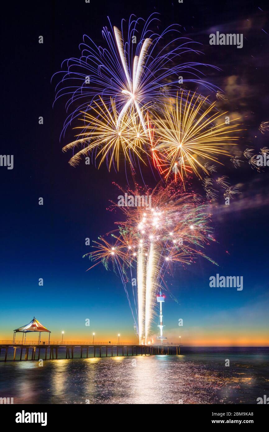 Colourful New Years Fireworks Display lighting up the sky and water off Brighton Jetty, Adelaide, South Australia Stock Photo