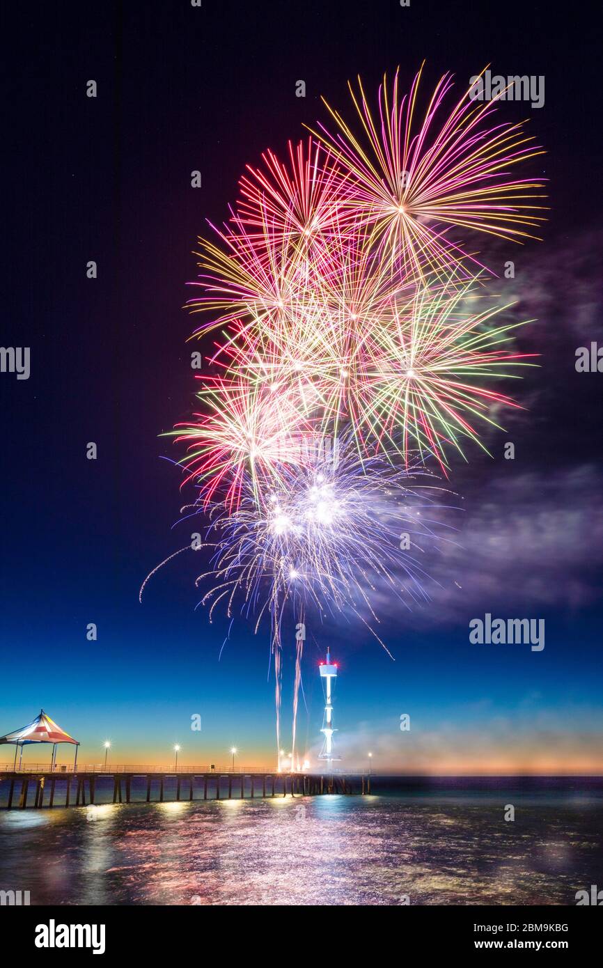 Colourful New Years Fireworks Display lighting up the sky and water off Brighton Jetty, Adelaide, South Australia Stock Photo