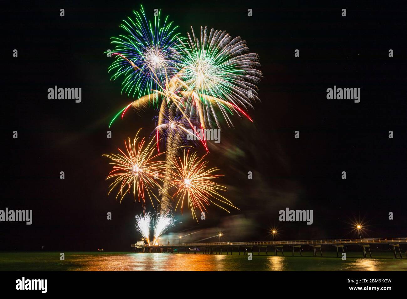 Colourful New Years Fireworks Display lighting up the sky and water off Glenelg Jetty, Adelaide, South Australia Stock Photo