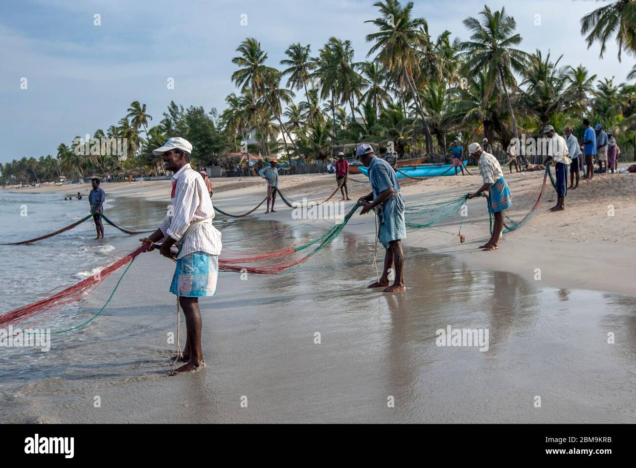 Fisherman pull their fishing net attached to hundreds of metres of rope  onto Uppuveli beach in eastern Sri Lanka Stock Photo - Alamy
