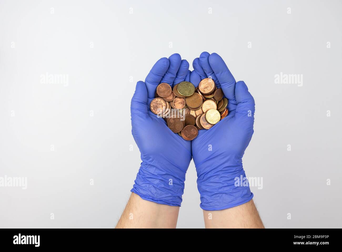 Hands with protection gloves holding Spanish Euro cent coins Stock Photo