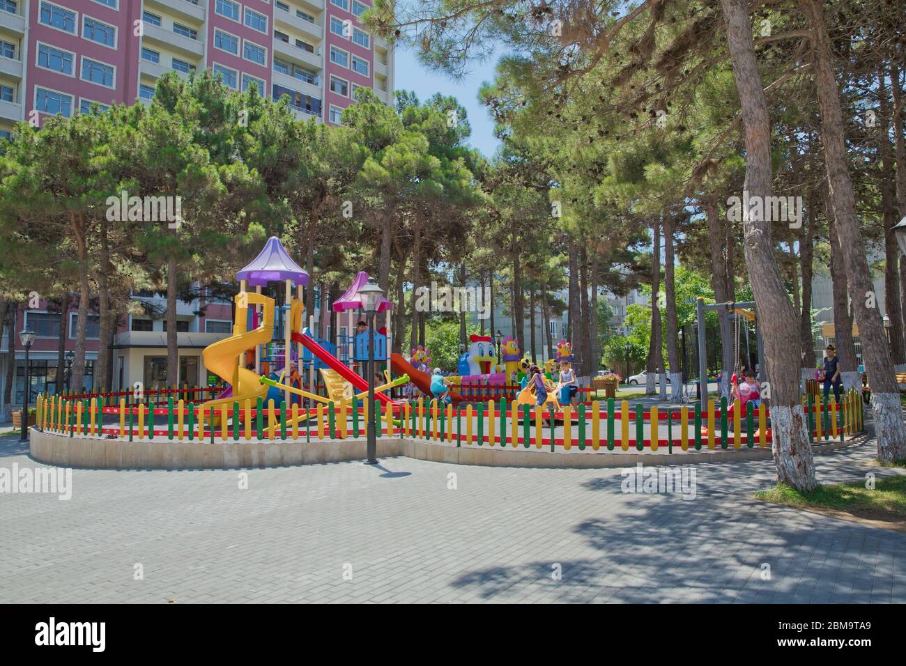 Children kids playground with play equipment outdoor. Kids playground with slides in the park. Pine trees . play ground colorfull big plastic toy set Stock Photo