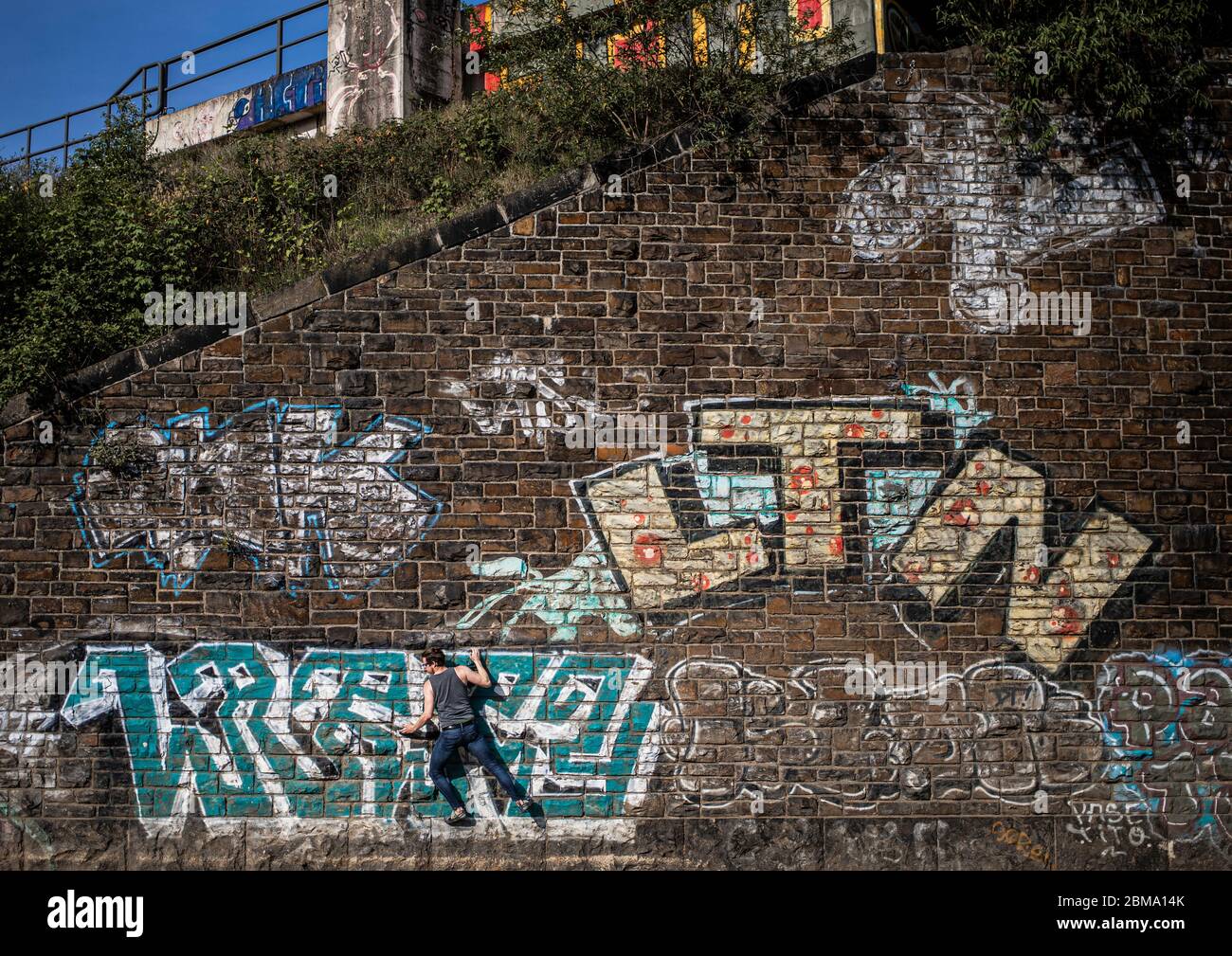Kšln, Eifelwall, 07.05.2020: Zwei MŠnner bouldern an einer mit Graffiti besprayten alten Mauer. Stock Photo