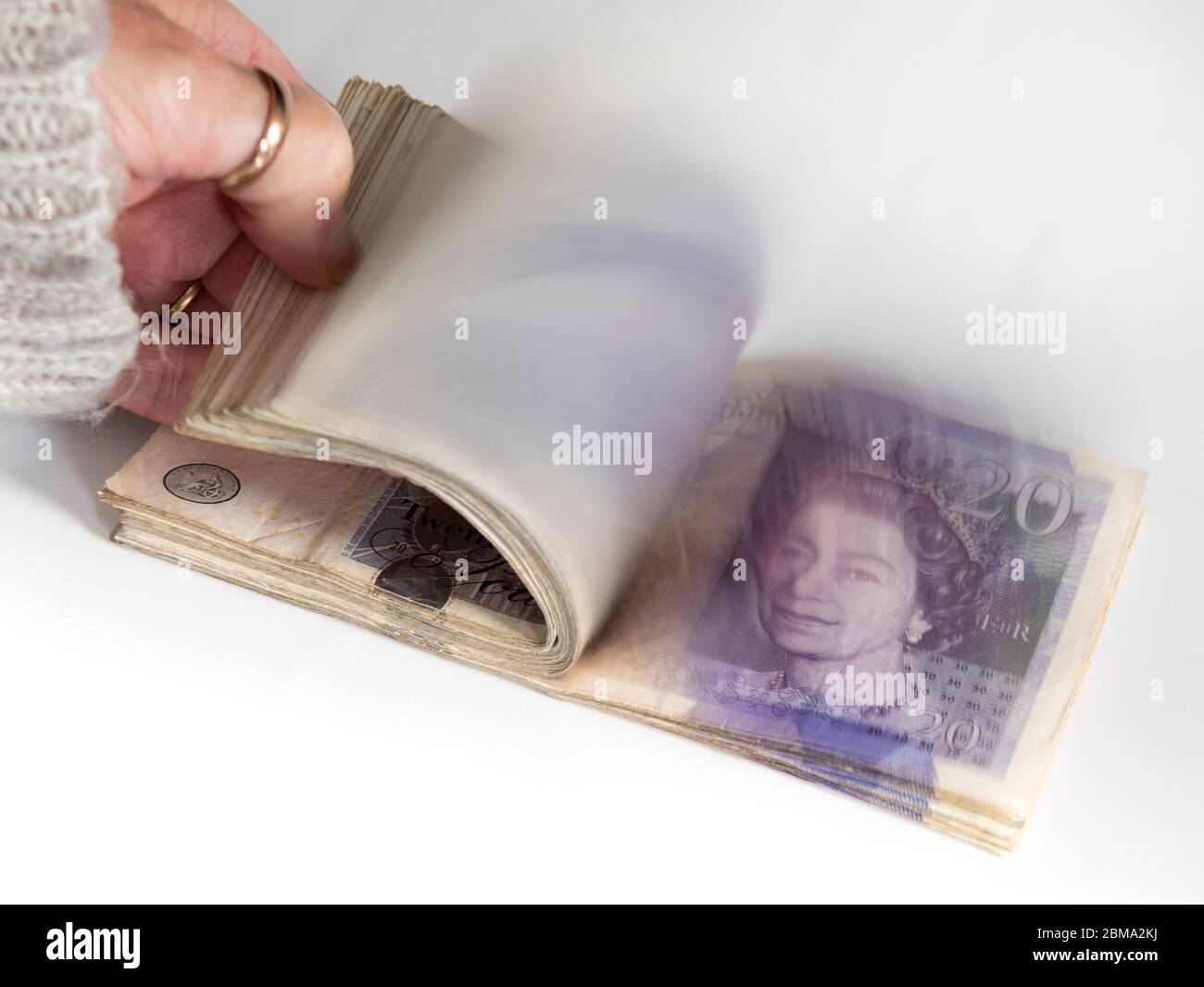 Woman counting twenty pound notes on a white background Stock Photo