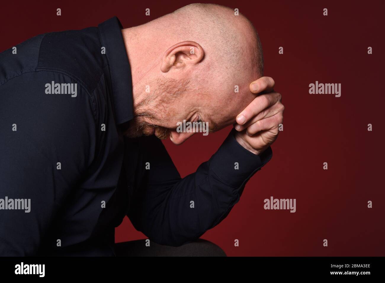 portrait of a desperate man on red background Stock Photo