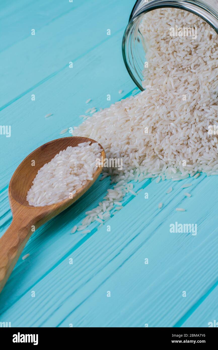 White rice grains with wooden spoon Stock Photo - Alamy