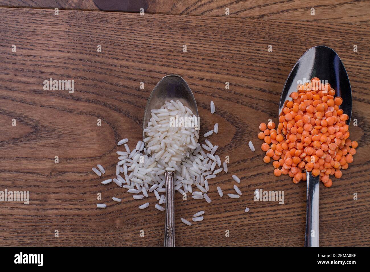Teaspoon of rice and tablespoon of orange lentils Stock Photo Alamy