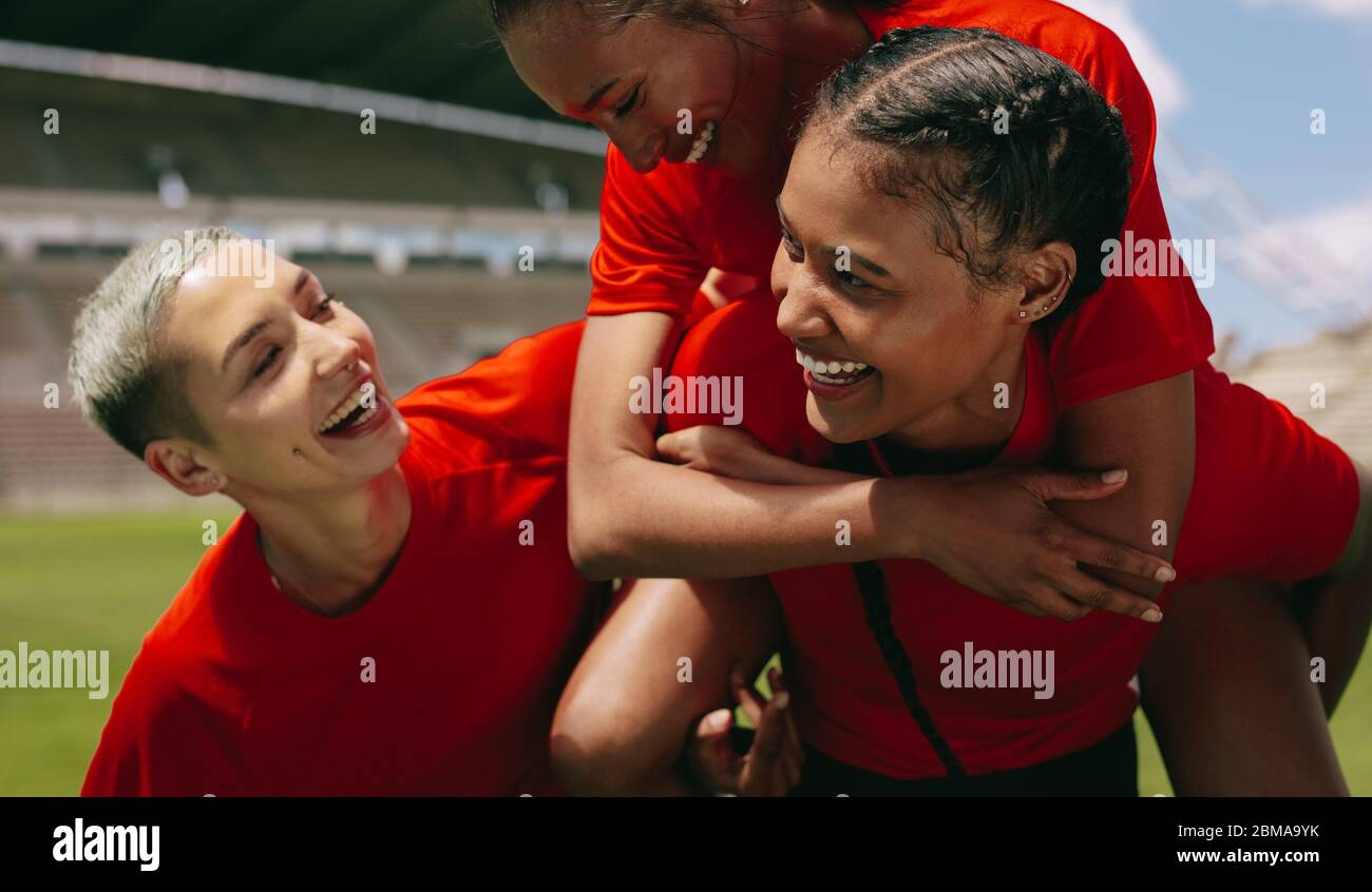 Woman soccer players celebrating a win. Female football players celebrating a goal during the match on the field. Stock Photo