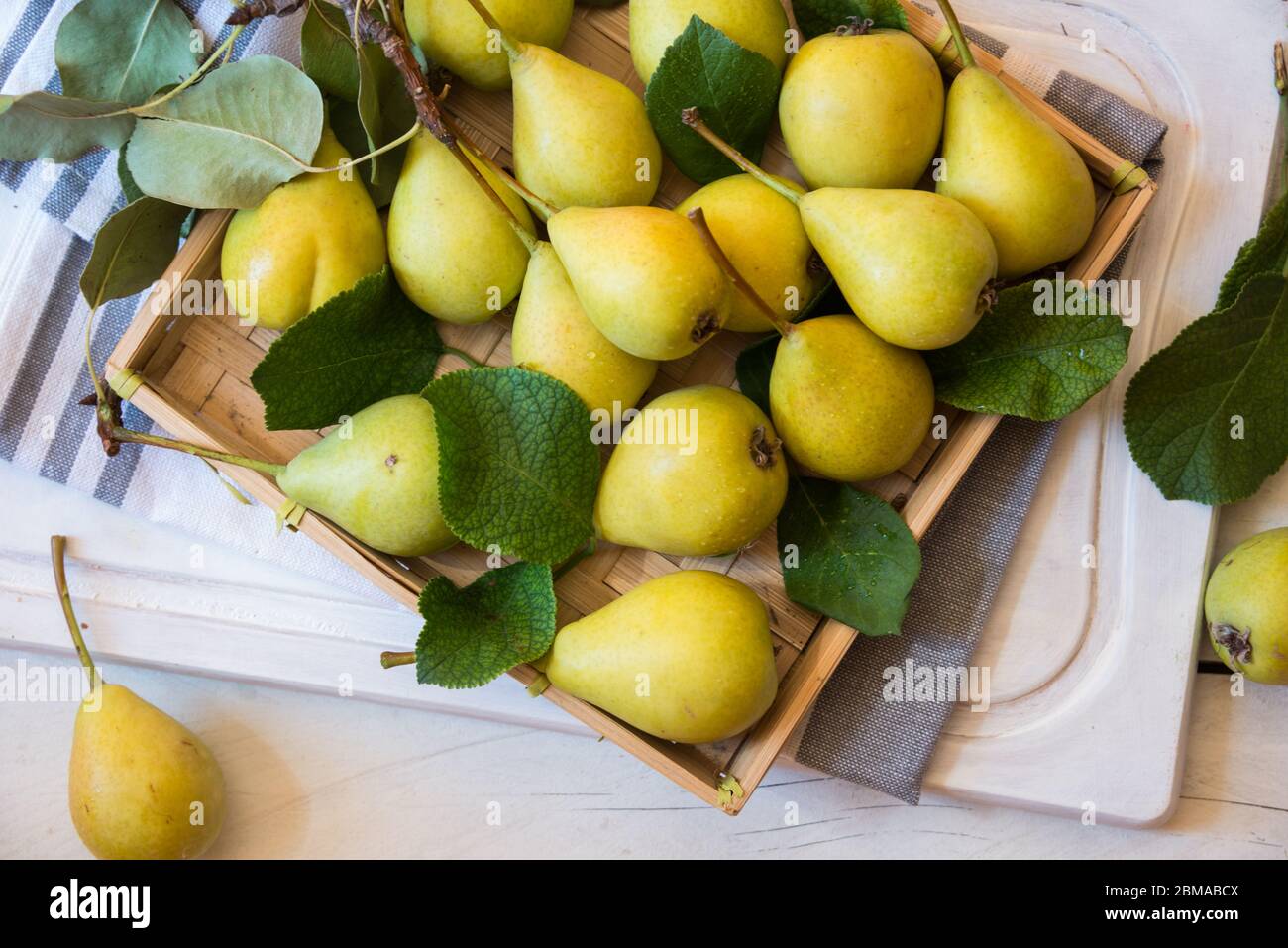 https://c8.alamy.com/comp/2BMABCX/fresh-organic-pears-fruits-with-leaves-on-white-wood-2BMABCX.jpg