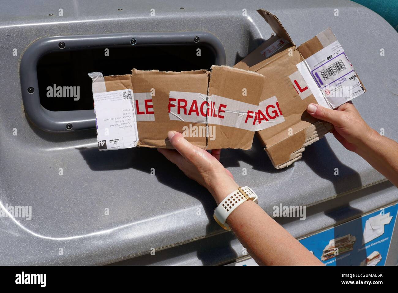 Paper, cardboard packaging being placed in large plastic recycling bin in the Ariege region of southern France Stock Photo