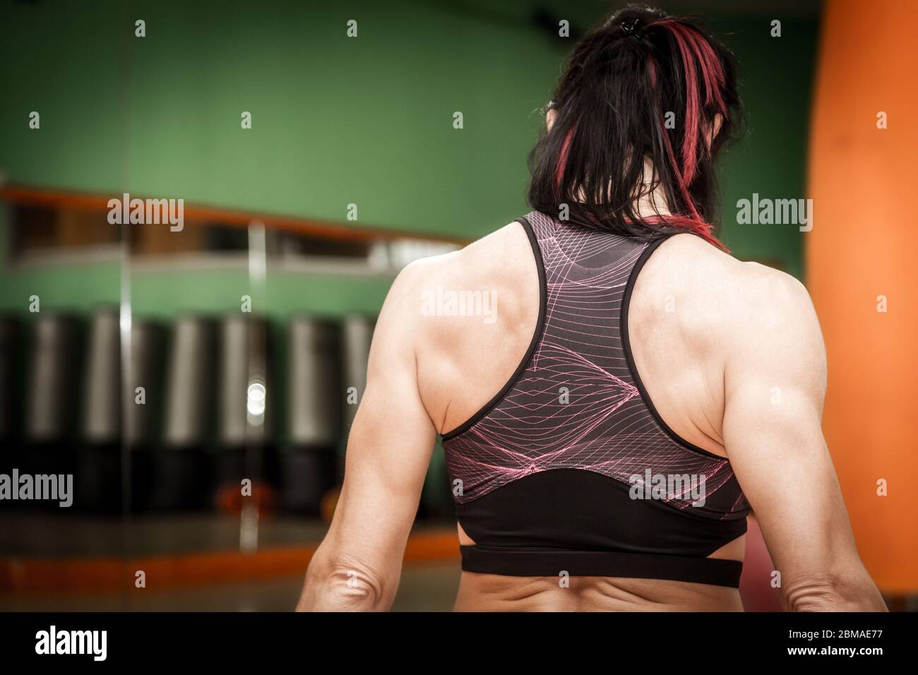 Woman athlete doing exercises with weights and dumbbells in the