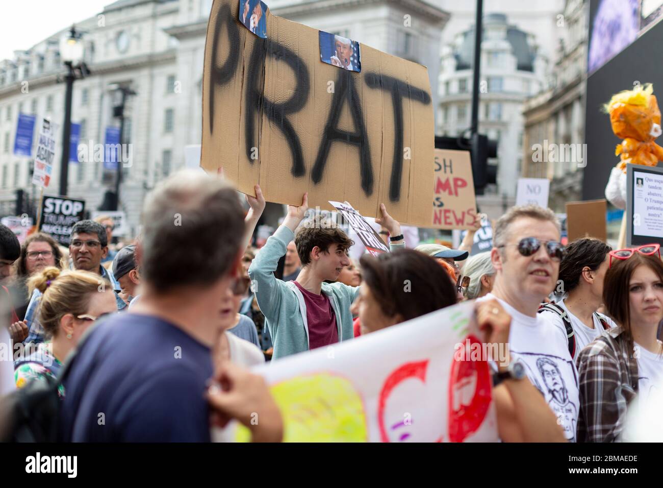 A young man holding up a sign reading 'Prat', at the protest and demonstration against Donald Trump's visit to London, 13 July 2018 Stock Photo
