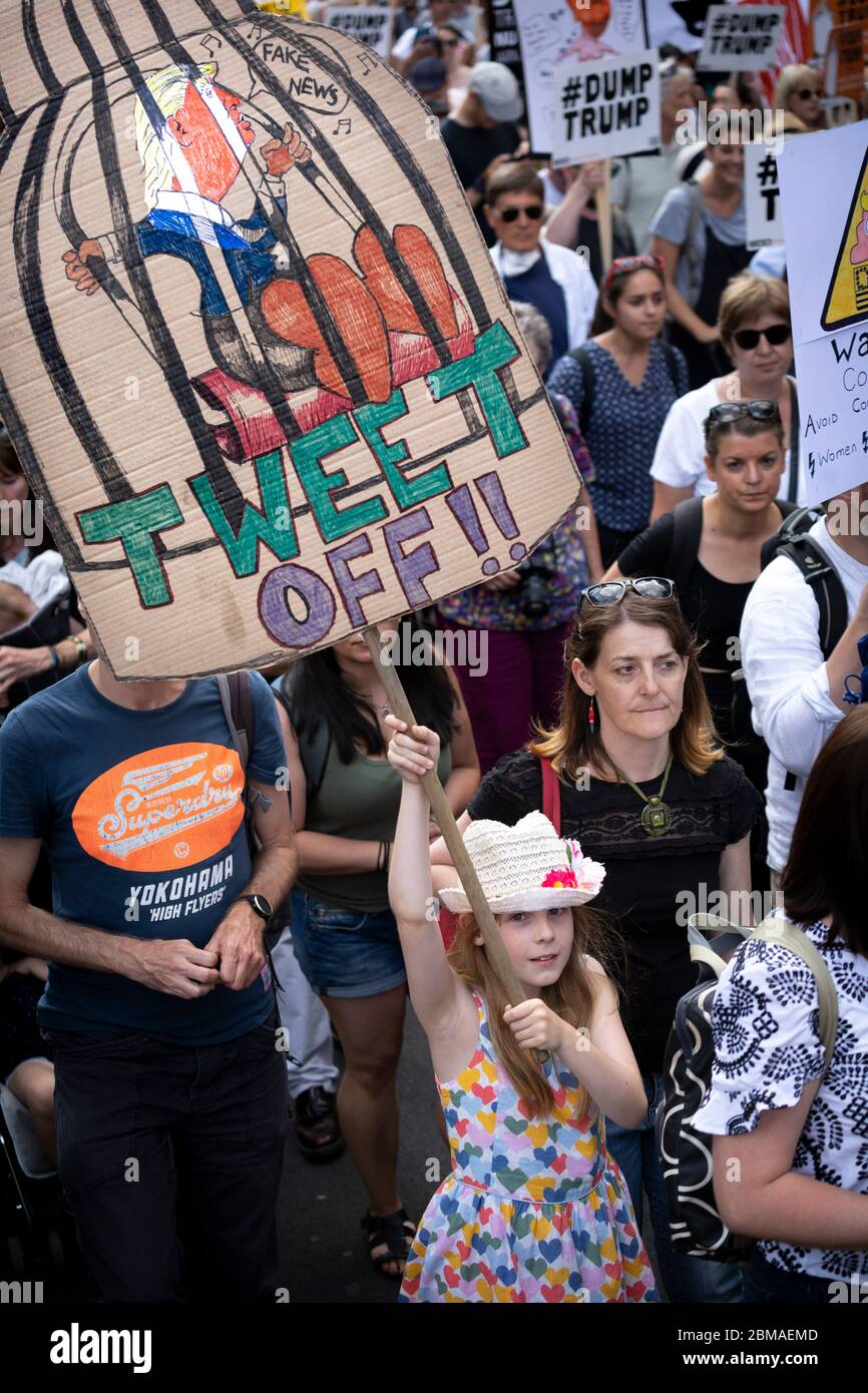 A young girl holding up a sign with a picture of Donald Trump in a bird cage and text reading 'Tweet Off!!', at a protest in London Stock Photo