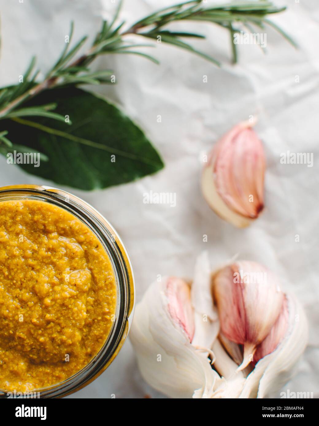 Download Glass Jar Of Yellow Wholegrain Mustard With Bulb Of Garlic And Sprig Of Rosemary With A Bay Leaf Sitting On White Textured Paper Background Stock Photo Alamy PSD Mockup Templates
