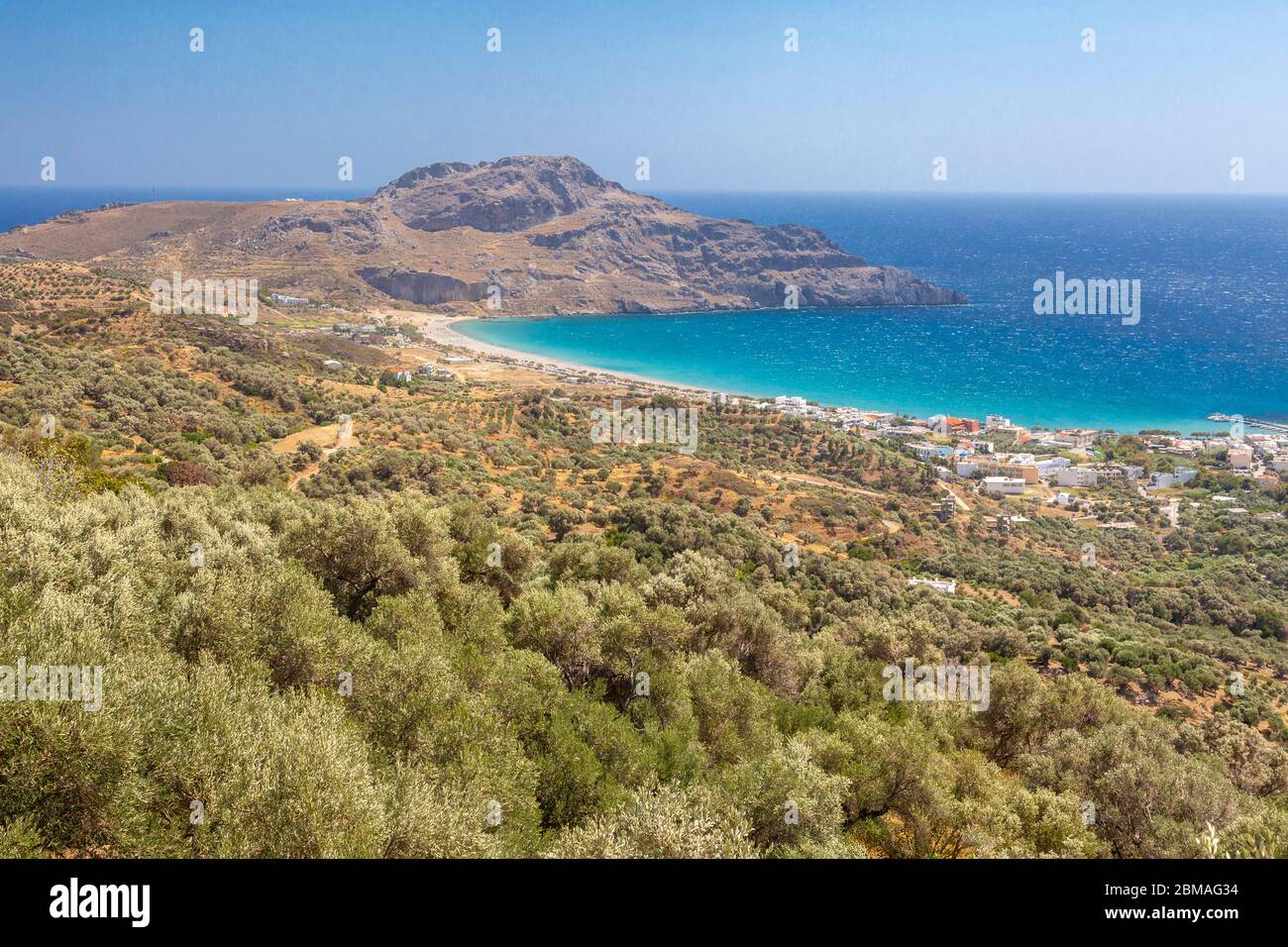 View over treetops towards a beach and headland, Plakias, Crete, Greece Stock Photo