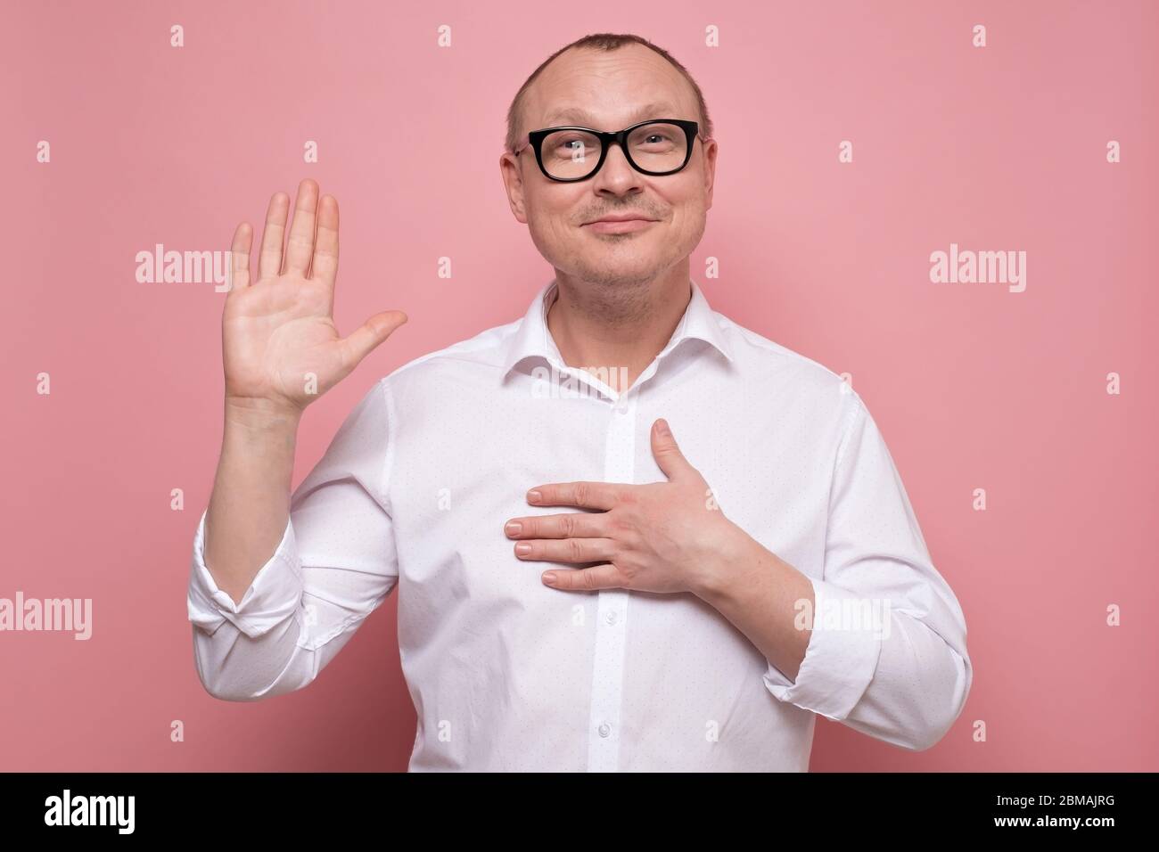 Mature man keeping hand on chest making promise, swearing to tell the truth Stock Photo