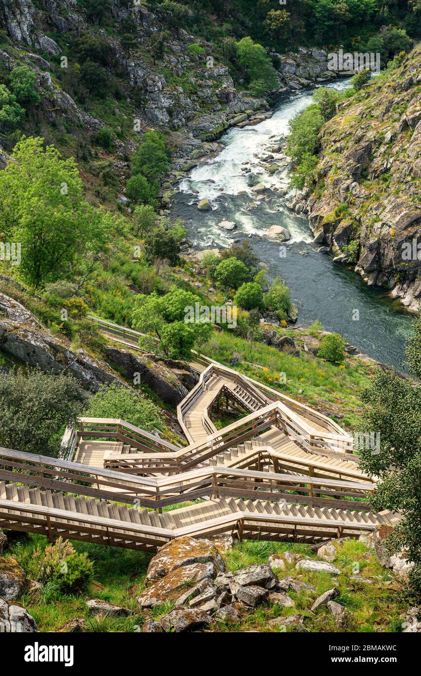 Arouca, Portugal - April 28, 2019: Landscape of the Paiva Walkways, with a winding staircase in the foreground and the Paiva river with its rapids in Stock Photo