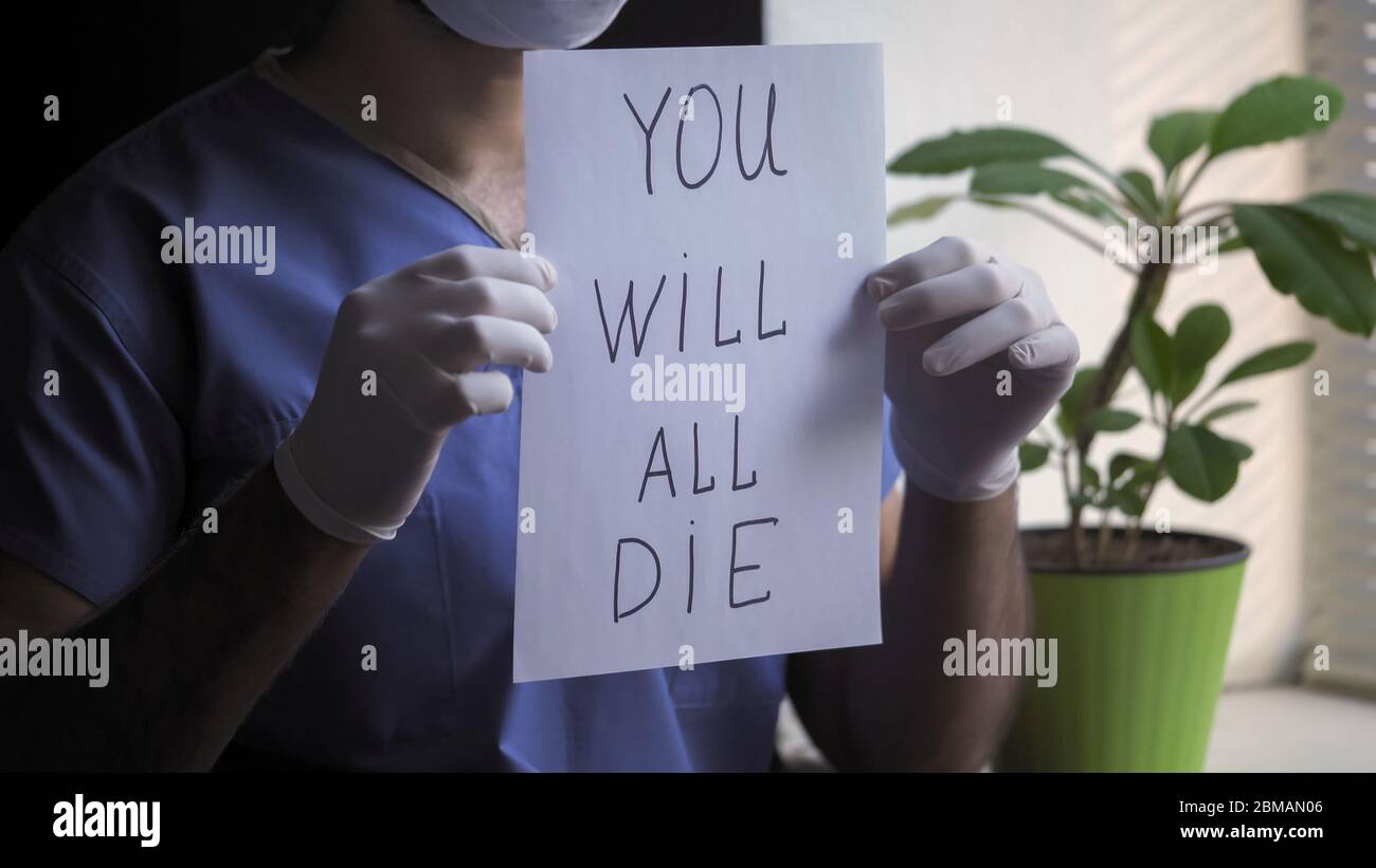 Male Doctor Shows Bad Prediction about death Holding Paper Blank with an inscription that everyone will die. Unfavorable prognosis of the disease Stock Photo