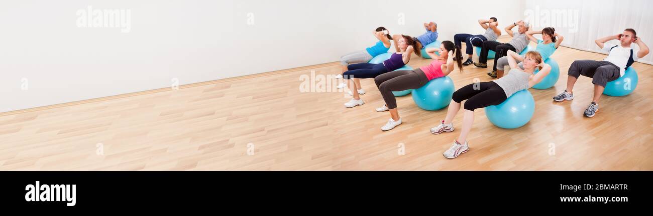Core Training Fitness Exercise. Men And Women In Gym Stock Photo