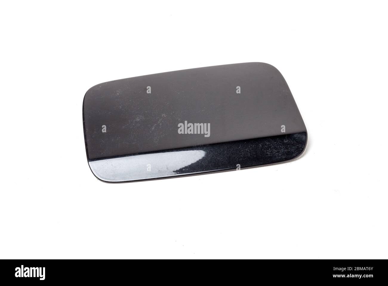 Black gas tank hatch on a white isolated background in a photo studio. Spare part car body cover