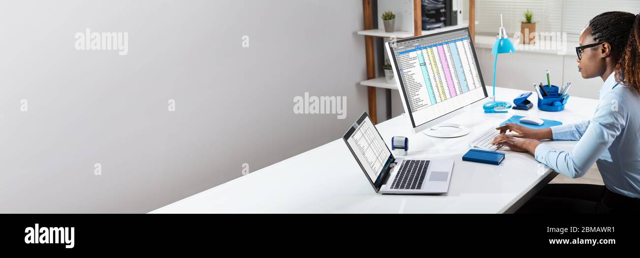 Black Person Working With Spreadsheet Data On Computer Screen Stock Photo