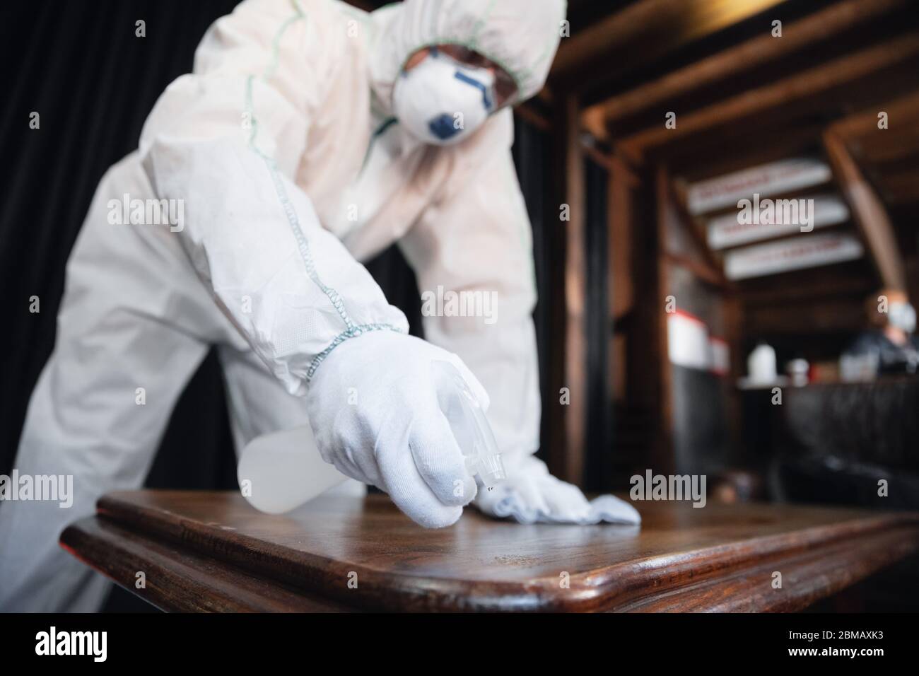 Coronavirus Pandemic. A disinfector in a protective suit and mask sprays disinfectants in house or office. Protection against COVID-19 disease. Prevention of spreding pneumonia virus with surfaces. Stock Photo