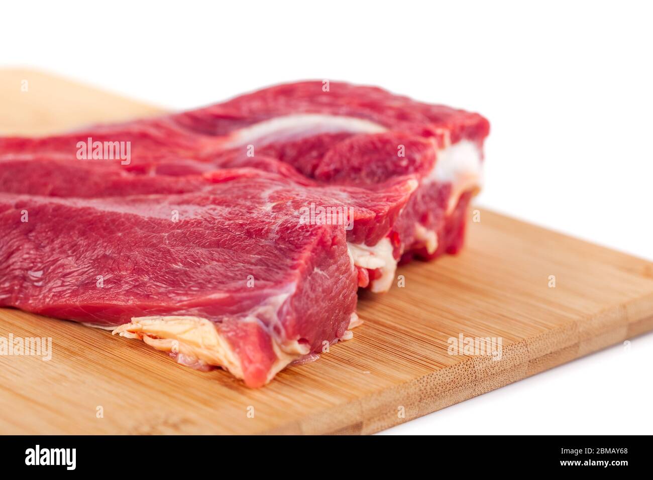 Raw meat on wooden board isolated on white background Stock Photo - Alamy