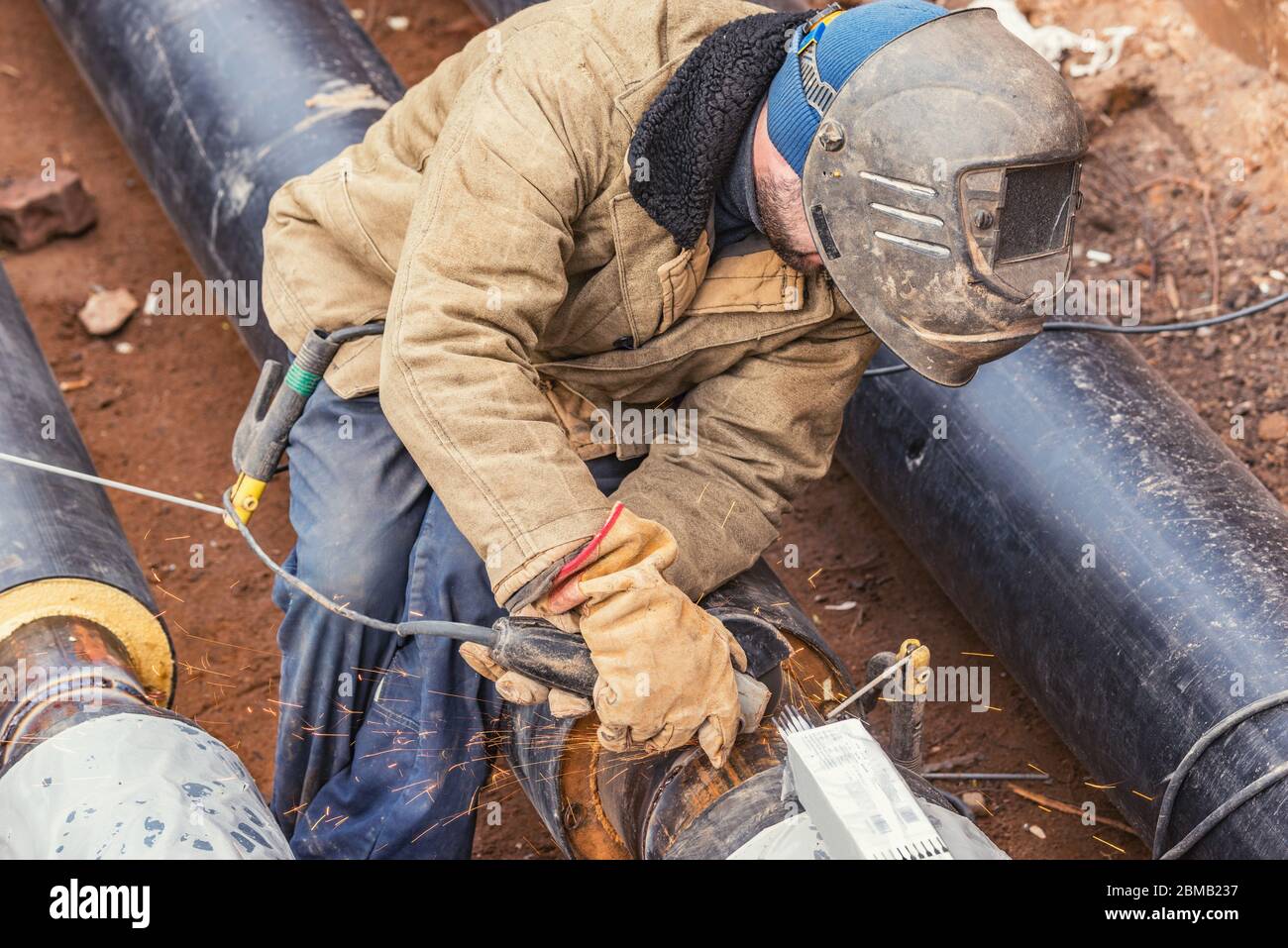 Worker grinds the seam after welding of the pipes Stock Photo Alamy