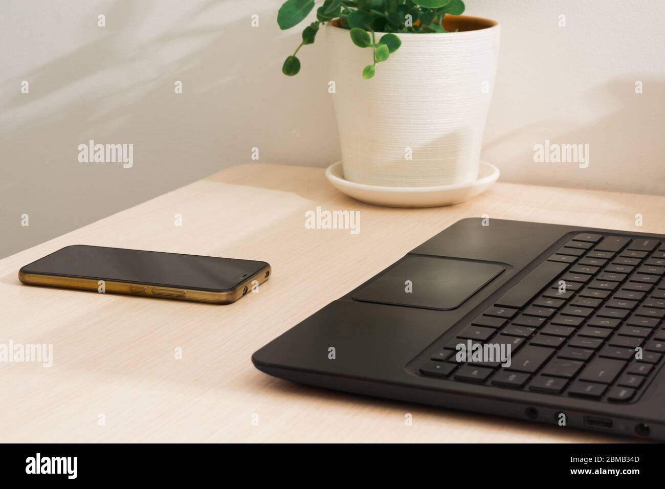 Nobody on working place at home. Laptop and phone on table. Remotely work. Freelance concept with onlline job Stock Photo