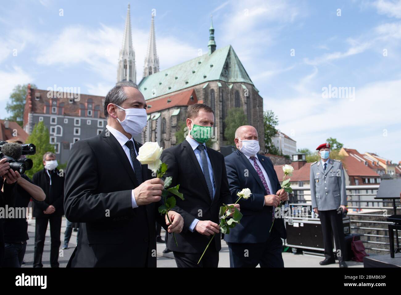 08 May 2020, Saxony, Görlitz: Octavian Ursu (CDU, l-r), Lord Mayor of Görlitz, Michael Kretschmer (CDU), Prime Minister of Saxony, and Siegfried Deinege (non-partisan), former Lord Mayor of Görlitz, hold during a memorial service on the Old Town Bridge in front of St. Peter's Church white roses. They wear masks against the novel coronavirus. On 8 May is the 75th anniversary of the end of the Second World War and the liberation from National Socialism. Photo: Sebastian Kahnert/dpa-Zentralbild/dpa Stock Photo