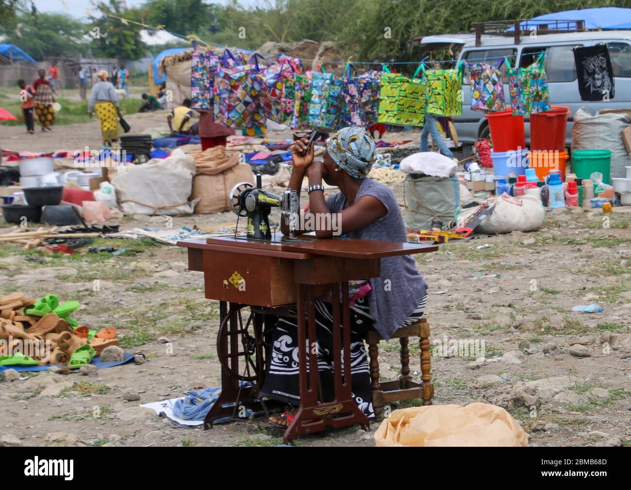 Seamstress with manual sewing machine awaits customers at the Frontier Market, Tanzania Stock Photo