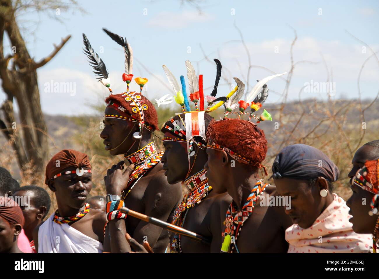 Masai (Also Maasai) Tribesmen an ethnic group of semi-nomadic people. Warriors with traditional headdress made of colourful feathers and ochre hair . Stock Photo