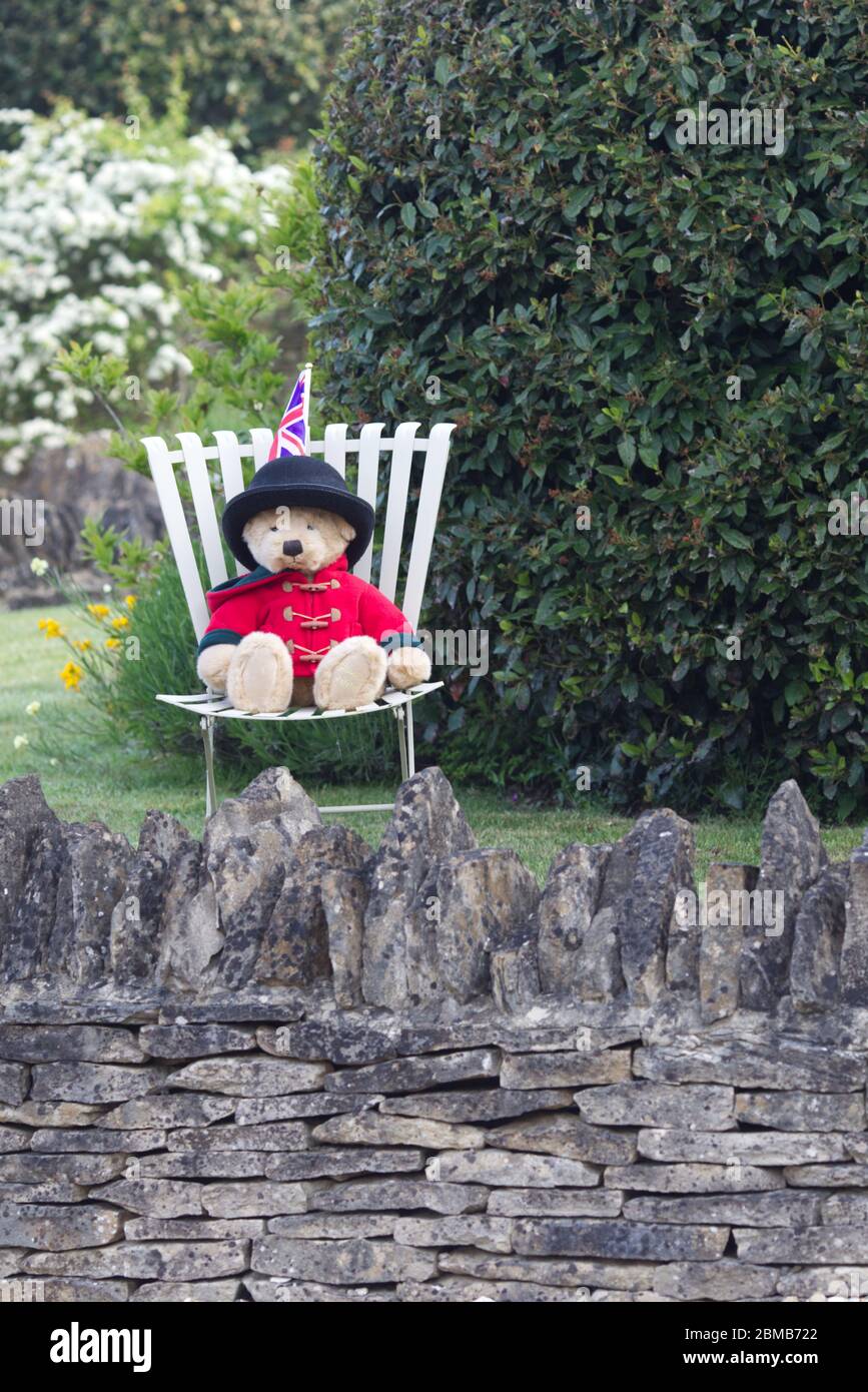 V E Day Teddy bear sitting on a chair in the garden. Stock Photo