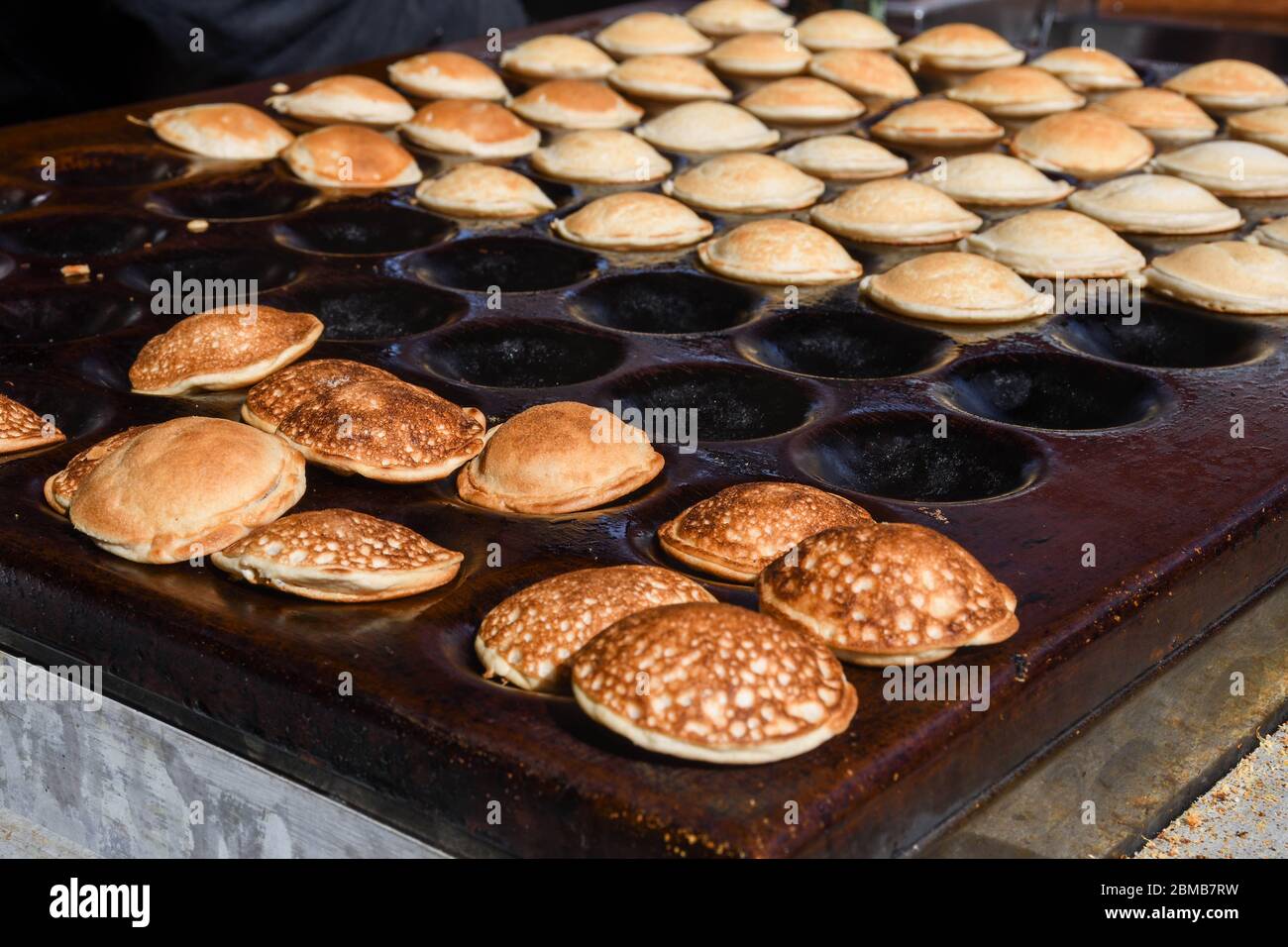 Traditional Dutch Poffertjes, poffertje, small, fluffy mini, baby pancakes  made in cast iron poffertjes pan Stock Photo - Alamy