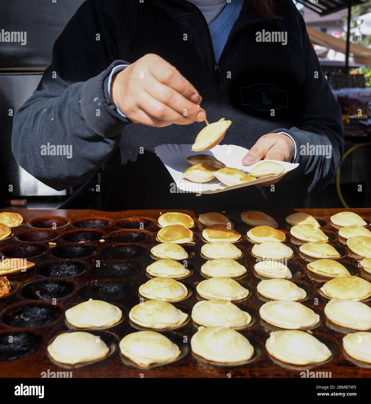 Traditional Dutch Poffertjes, poffertje, small, fluffy mini, baby pancakes  made in cast iron poffertjes pan Stock Photo - Alamy