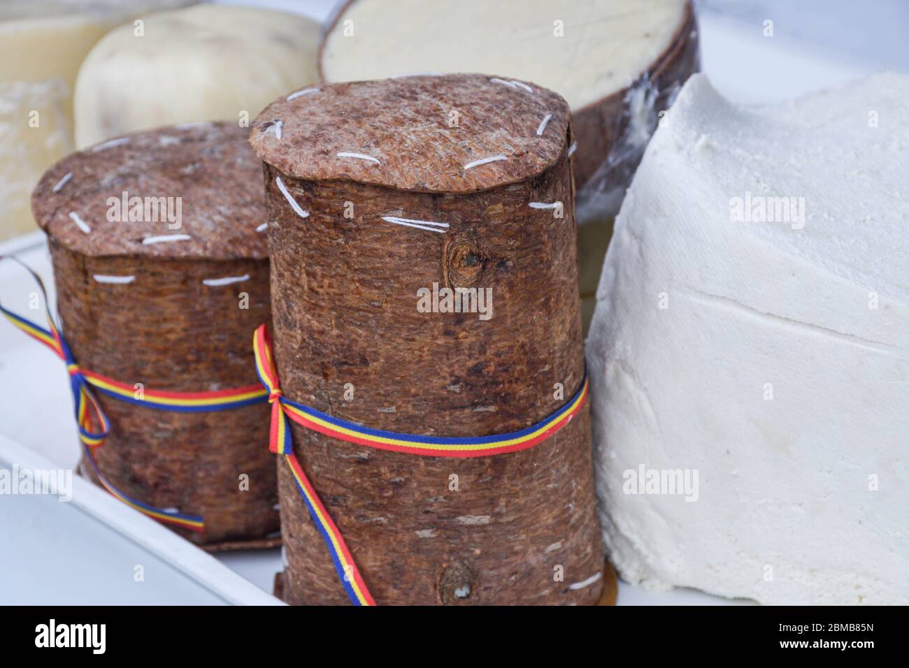 Branza de burduf, traditional sheep's milk cheese from south of Transilvania, Romanian specialty cheese, yellow round shape goat cheese balls homemade Stock Photo