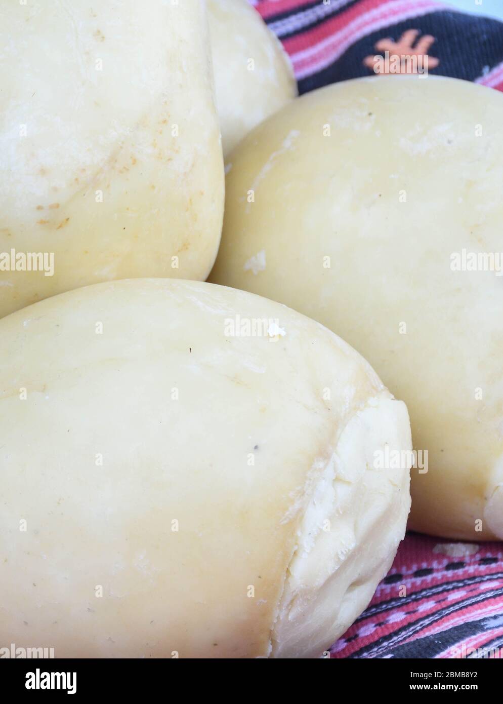 Branza de burduf, traditional sheep's milk cheese from south of Transilvania, Romanian specialty cheese, yellow round shape goat cheese balls homemade Stock Photo