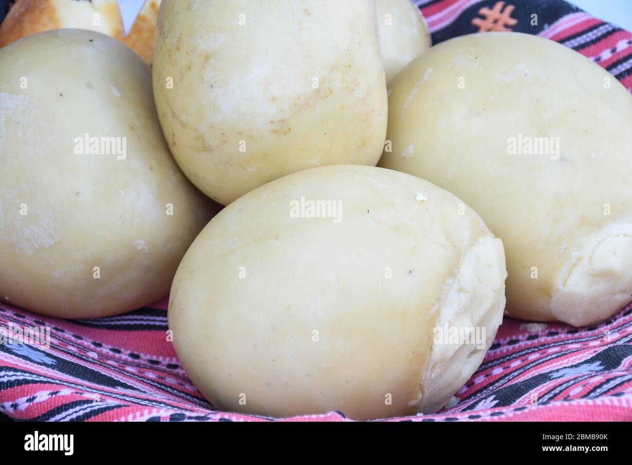 Branza de burduf, traditional sheep's milk cheese from south of Transilvania, Romanian specialty cheese, yellow round shape goat cheese balls homemade Stock Photo