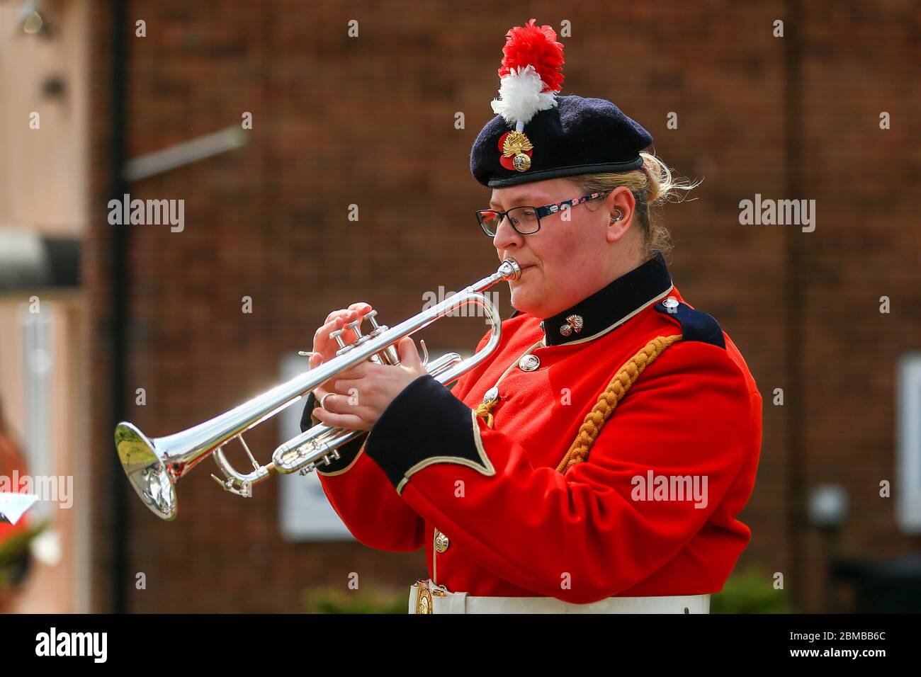 Dudley, UK. 8th May, 2020. Trumpeter Sam Chater, 35, of the band of the Royal Regiment of Fusiliers, Warwickshire, plays the Last Post outside her home in Dudley, West Midlands, UK. Credit: Peter Lopeman/Alamy Live News Stock Photo
