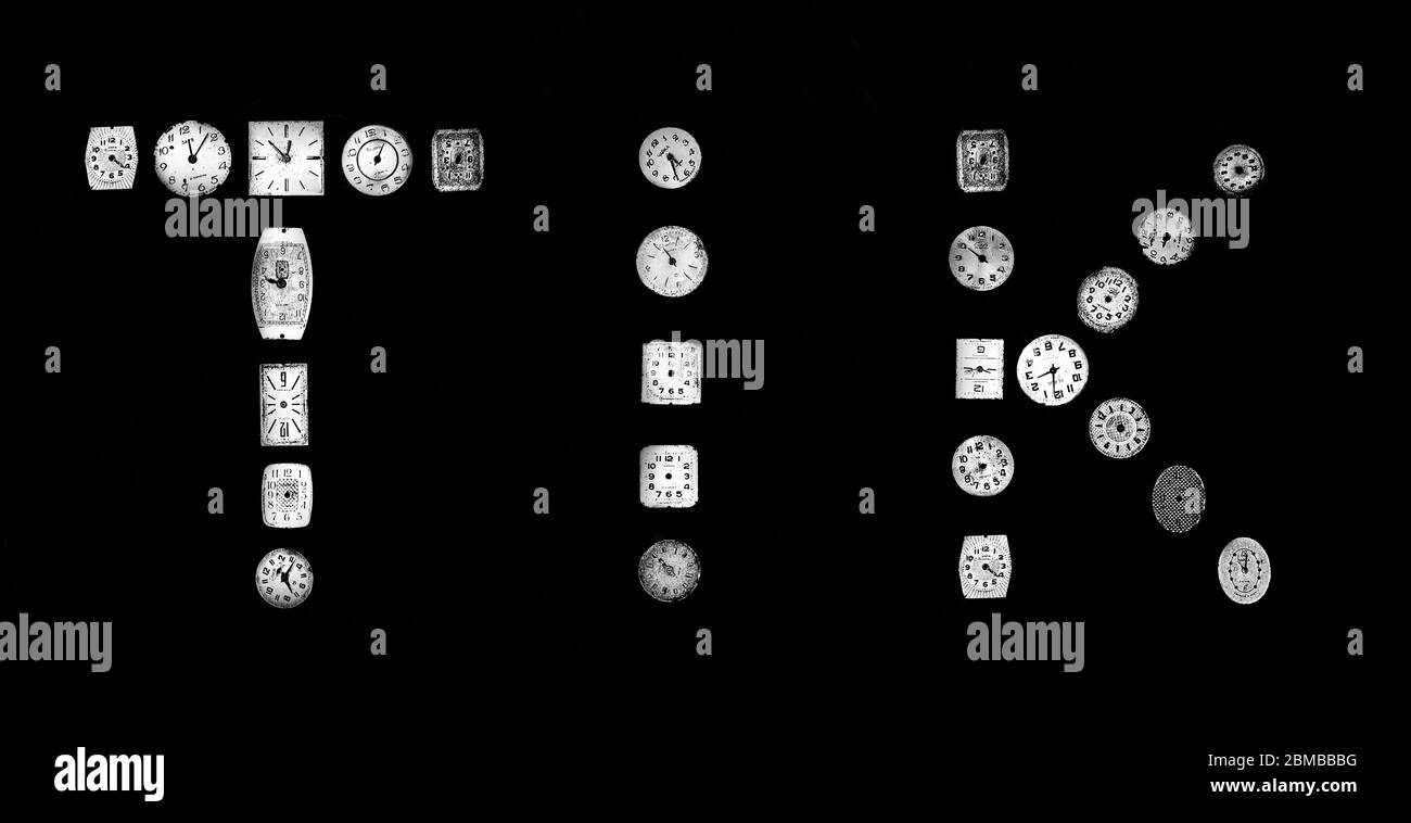 Monochrome still life of old watch faces depicting the word Tik Stock Photo