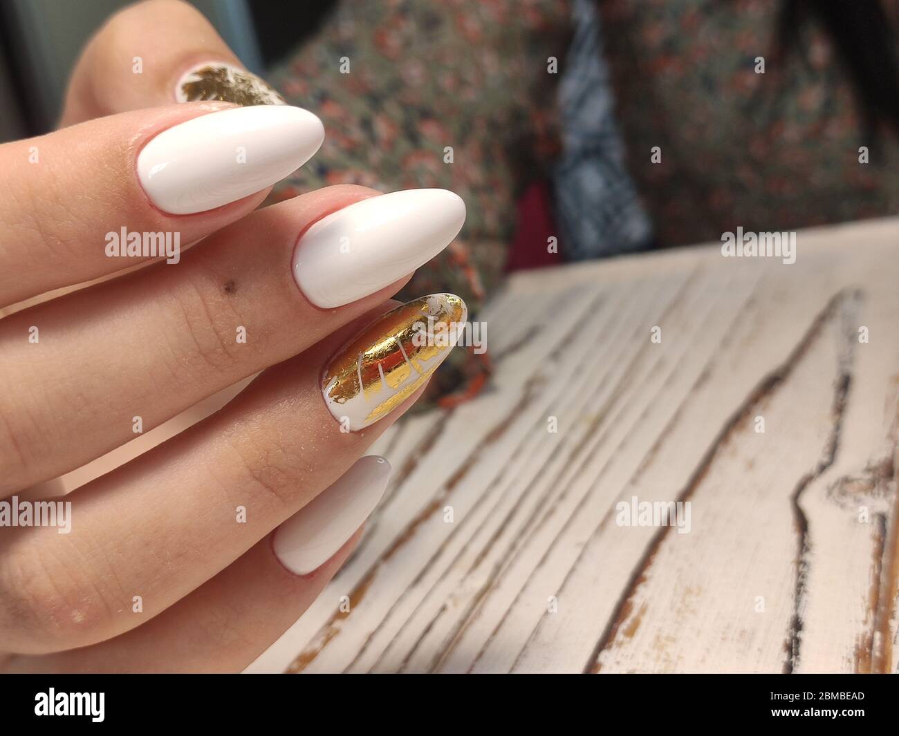 Golden nail art manicure. Holiday style bright manicure with gems and  sparkles. Bottle of nail Polish. Fashion rings Stock Photo
