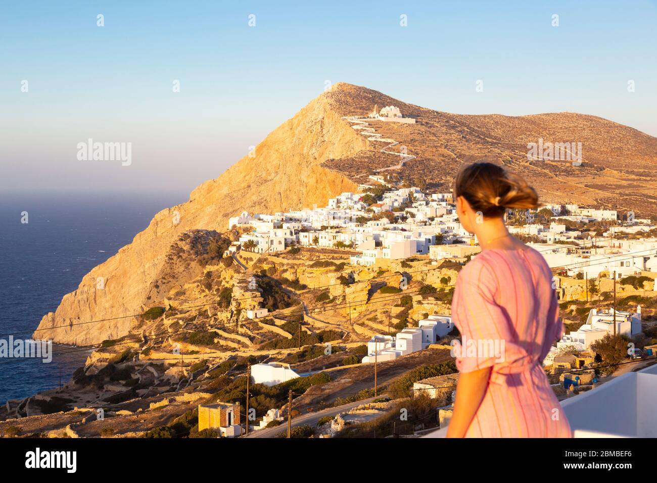 A girl looking out over the Folegandros Municipality at sunset, Folegandros, Cyclades Islands, Greece Stock Photo