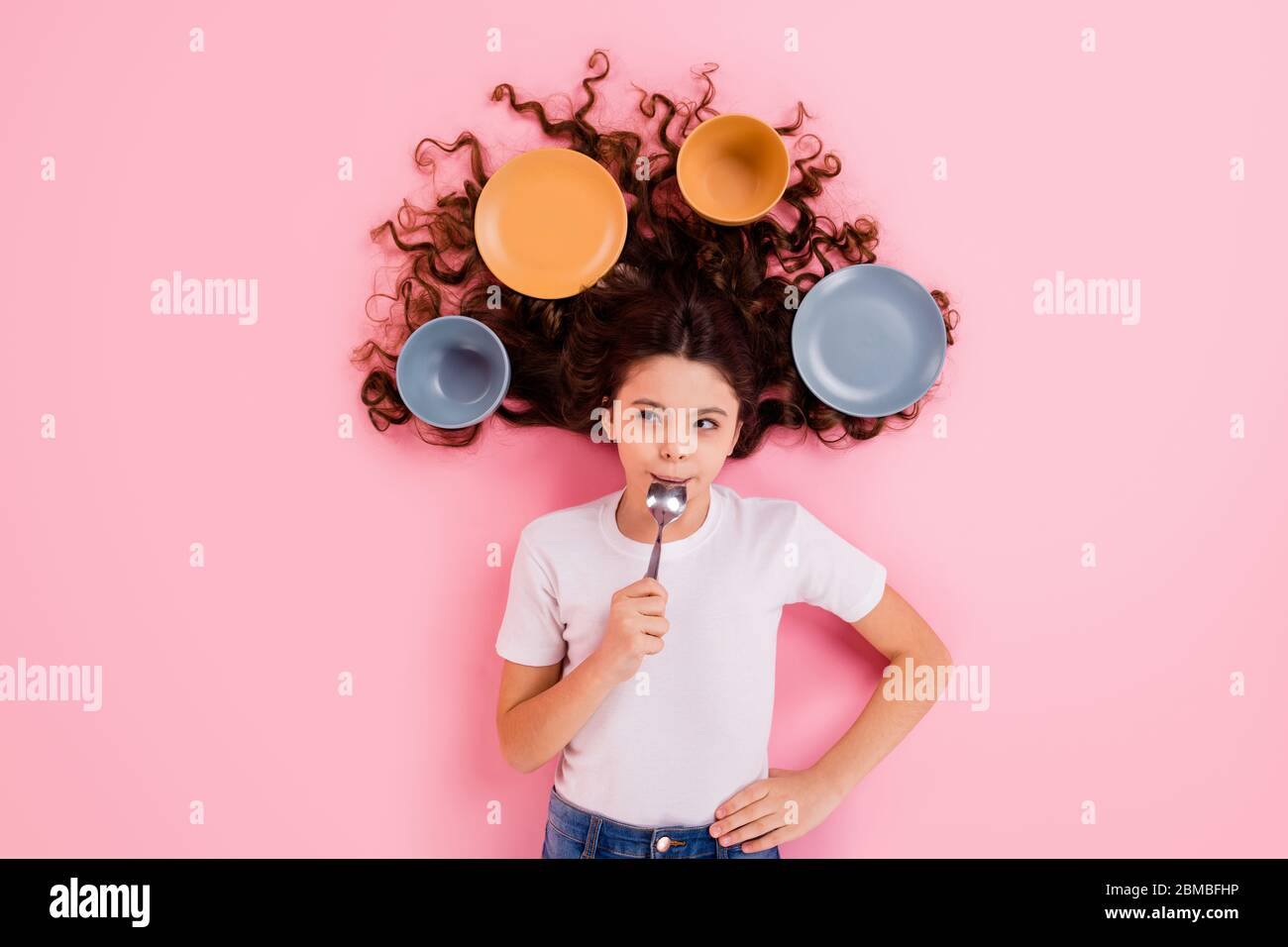 Top view above high angle flat lay flatlay lie concept portrait of her she nice attractive beautiful wavy-haired girl licking spoon dishes meal Stock Photo