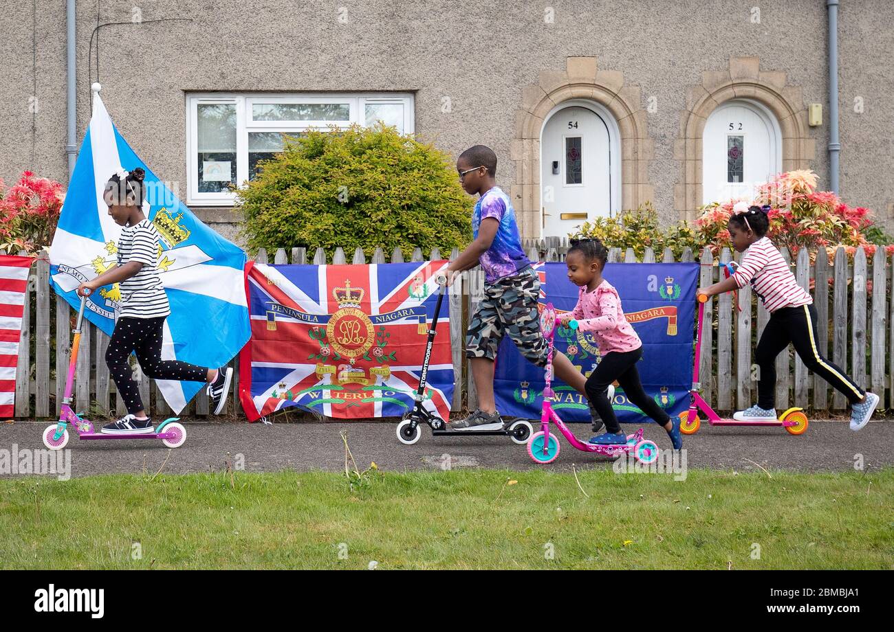 (left to right) Gabriella Williams, 7, Gregory Williams, 9, Carrisa Amaning, 4, and Claire Williams, 4, play on their scooters at a community commemoration party in the grounds of Haig Housing in Edinburgh to mark the 75th anniversary of VE Day. Stock Photo